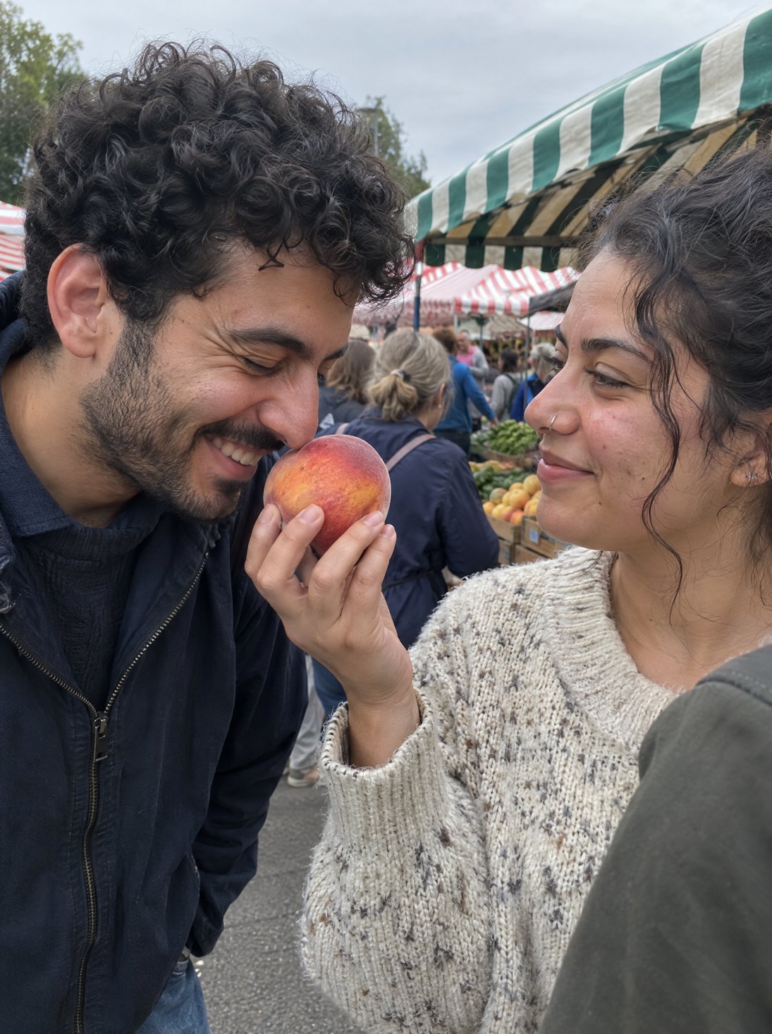 A couple at a farmers market sharing a peach