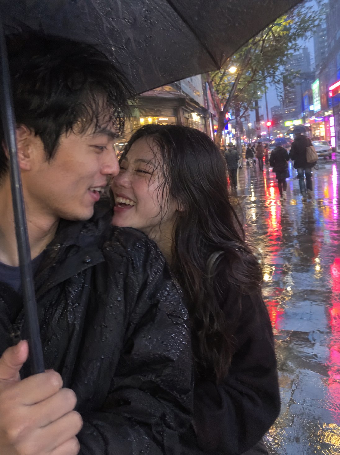 A couple sharing an umbrella on a rainy street